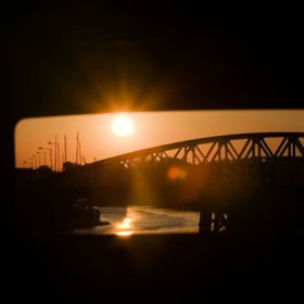 Sunset  over a bridge, through a bin.