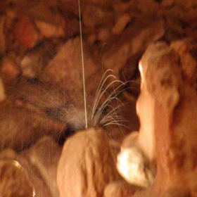 A DROP OF WATER FALLING ON A STALACTITE