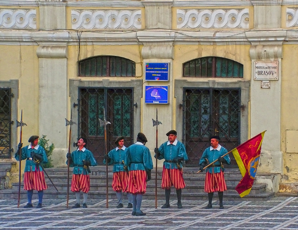 Traditionally dressed men in front of the Brasov Historical Museum